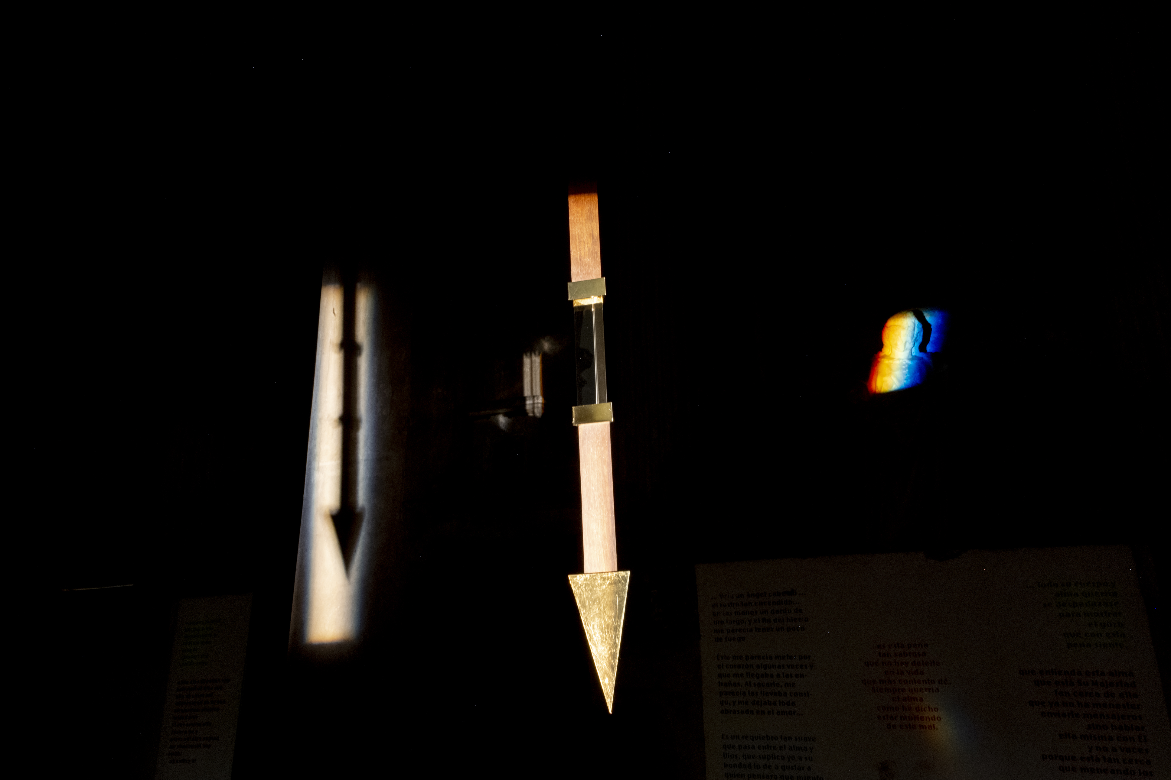 Transverberación/Transverberation,  2022 
Instalación con Espejos, Flecha de nogal con prisma de cristal, latón, y hoja de oro, citas de Santa Teresa de Ávila, Iluminación. Installation wit 2 mirrors, walnut arrow with a crystal prism, brass and gold leaf, quotations from St Teresa of Avila, lighting. 